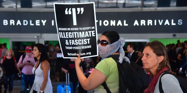 Activists hold placards outside the International Arrivals section at Los Angeles International Airport on June 29, 2017, protesting President Donald Trump's ban temporarily barring entry into the US from Libya, Iran, Somalia, Sudan, Syria and Yemen goes into effect.The ban prevents the issuance of visas to travelers from the sixcountries for 90 days and places the refugee-entry program on hold for 120 days. / AFP PHOTO / FREDERIC J. BROWN (Photo credit should read FREDERIC J. BROWN/AFP/G