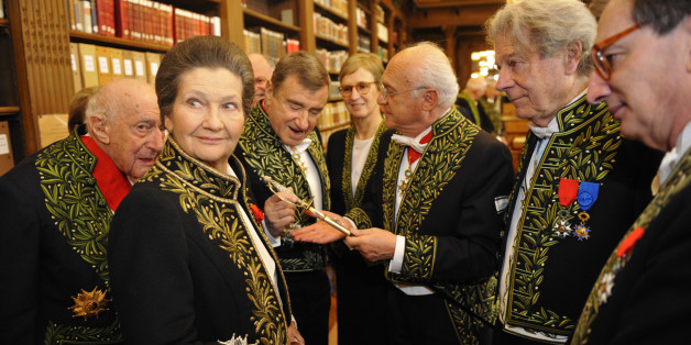 French politician Simone Veil (2nd L), dressed in the French Academician's uniform of a black jacket embroidered in green laurel leaves, speaks with Academicians in the library of the Institut de France before a ceremony in Paris March 18, 2010. Veil was inducted into the French Academy (Academie Francaise) as an 'Immortels'. REUTERS/Philippe Wojazer (FRANCE - Tags: POLITICS ENTERTAINMENT)