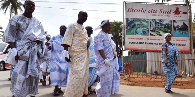 People walk near the hotel Etoile du Sud in Grand Bassam on March 13, 2016 during a commemoration ceremony for the first anniversary of the 2016 Grand Bassam beach terrorist attack, resulting in the death of 19 people. The attack that killed 19 people, the first of its kind in the Ivory Coast, was claimed by Al-Qaeda in the Islamic Maghreb, which has also carried out assaults on tourist hotspots in Mali and Burkina Faso. / AFP PHOTO / ISSOUF SANOGO (Photo credit should read ISSOUF SANOGO/