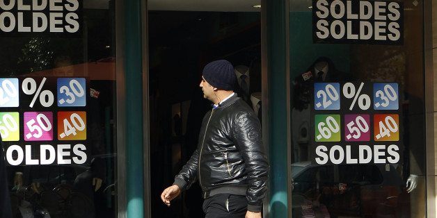 A man looks at sale signs placed on a shop's windows as he walks in central Tunis February 5, 2013. REUTERS/ Zoubeir Souissi (TUNISIA - Tags: SOCIETY)