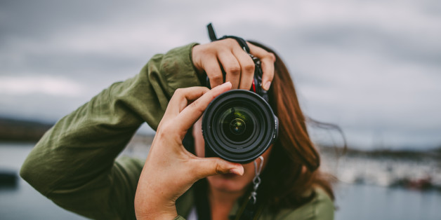 A young woman using a DSLR camera
