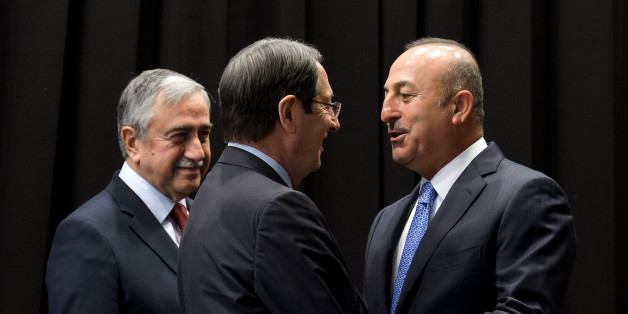 Turkish Foreign Minister Mevlut Cavusoglu (R) greets Greek Cypriot President Nicos Anastasiades (C) next to Turkish Cypriot Leader Mustafa Akinci (L) during peace talks in the Swiss resort of Crans-Montana on June 30, 2017.
More than 40 years after Turkish troops invaded northern Cyprus, the presence of tens of thousands of soldiers on the Mediterranean island still looms large over make-or-break peace negotiations this week. / AFP PHOTO / Fabrice COFFRINI (Photo credit should read FABRICE COFFRINI/AFP/Getty Images)