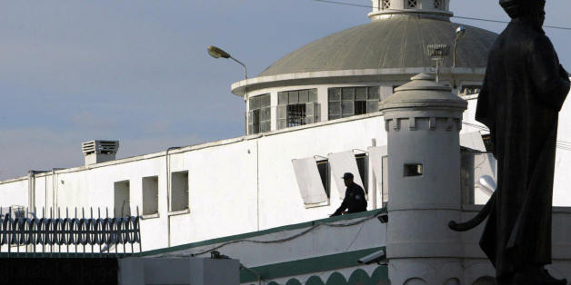 Algiers, ALGERIA: An Algerian policeman stands guard at the Serkadji prison as a statue of Turkish Kheireldine Barberousse is seen (left), in Algiers 04 March 2006. Scores of Algerian prisoners held over terrorist offences in an armed Islamist insurgency became free men Saturday, walking out of the capital's central prison to be welcomed by their families. The detainees, watched by an AFP correspondent, left the Serkadji jail in Algiers in groups of five to seven men at a time, beneficiaries of