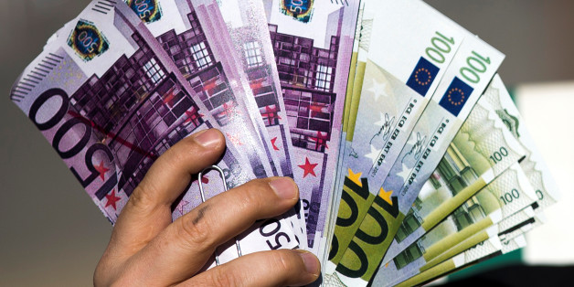 An activist shows fake banknotes during a demonstration outside the European Commission (EC) headquarters ahead of statements by the EC on the effectiveness of existing measures against tax evasion and money-laundering in light of the recent Panama Paper revelations, in Brussels, Belgium, April 12, 2016. REUTERS/Yves Herman