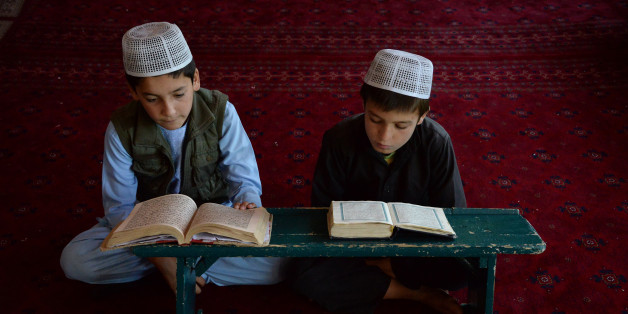 TOPSHOT - Afghan children read the Koran at a madrasa during the holy month of Ramadan in Ghazni on June 13, 2017.Muslims throughout the world are marking the month of Ramadan, the holiest month in the Islamic calendar during which devotees fast from dawn until dusk. / AFP PHOTO / ZAKERIA HASHIMI (Photo credit should read ZAKERIA HASHIMI/AFP/Getty Images)