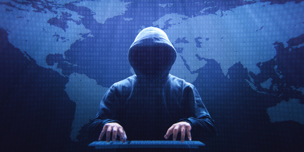 Anonymous computer hacker sitting in front of a virtual screen.