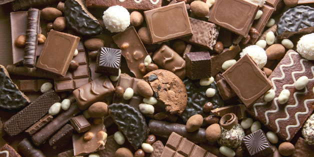 Chocolate background. Many pieces of chocolate, candies, cookies, biscuits, cakes and other sweets. Milk chocolate and dark chocolate. coconut candy