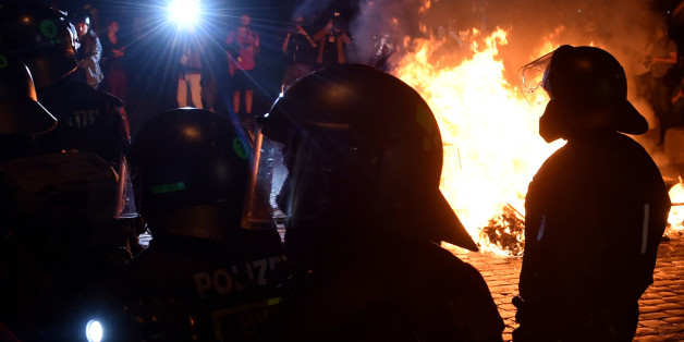 Police officers walk in front of a fire after the 'Welcome to Hell' rally against the G20 summit in Hamburg, northern Germany on July 6, 2017.
Leaders of the world's top economies will gather from July 7 to 8, 2017 in Germany for likely the stormiest G20 summit in years, with disagreements ranging from wars to climate change and global trade. / AFP PHOTO / Christof STACHE (Photo credit should read CHRISTOF STACHE/AFP/Getty Images)