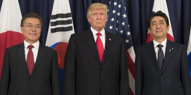 US President Donald Trump (C), Japanese Prime Minister Shinzo Abe (R) and South Korean President Moon Jae-in pose for photos before attending the Northeast Asia Security Dinner at the US Consulate General Hamburg on the sidelines of the G20 Summit in Hamburg, Germany, July 6, 2017.Leaders of the world's top economies will gather from July 7 to 8, 2017 in Germany for likely the stormiest G20 summit in years, with disagreements ranging from wars to climate change and global trade. / AFP PHOTO / SA