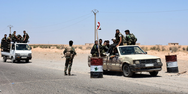 A picture taken on July 8, 2017 shows members of the Syrian pro-government forces riding in vehicles on the road near the Syrian village of Hanna Safar, on the western outskirts of Raqa province. / AFP PHOTO / George OURFALIAN (Photo credit should read GEORGE OURFALIAN/AFP/Getty Images)