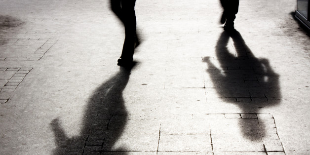 Shadow of two person on pattered sidewalk in black and white