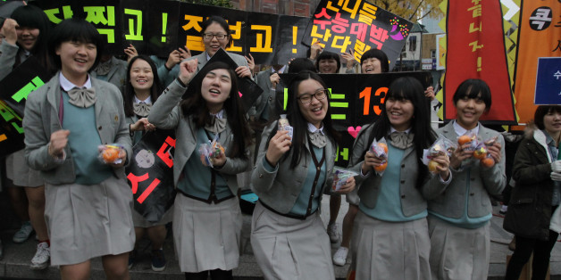 SEOUL, SOUTH KOREA - NOVEMBER 08: South Korean high school girls cheer for their senior classmates taking the College Scholastic Ability Test on November 8, 2012 in Seoul, South Korea. More than 660,000 high school seniors and graduates sit for the examinations at 1,100 test centers across the country, where academic records are all important. Success in the exam, one of the most rigourous standardized tests in the world, enables students to study at Korea's top universities. (Photo by Chung S