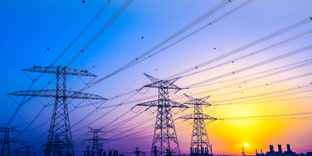 Electrical Pylons against vibrant twilight colors and a gorgeous sunset over Dubai Horizon.