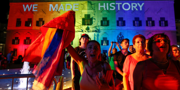 People celebrate in front of the rainbow-colour lit Auberge de Castille, the office of Prime Minister Joseph Muscat, after the Maltese parliament voted to legalise same-sex marriage on the Roman Catholic Mediterranean island, in Valletta, Malta, July 12, 2017. REUTERS/Darrin Zammit Lupi
