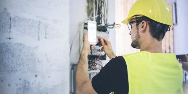 An electrician fixing up the wires and measuring volts