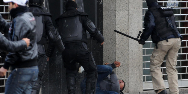 Tunisian policemen beat up a protester during a demonstration following the funeral of assassinated opposition leader Chokri Belaid on Habib Bourguiba Avenue in central Tunis on February 8, 2013. Tunisian police fired tear gas at dozens of protesters in central Tunis and at the cemetery where slain Belaid is due to be buried AFP PHOTO / SALAH HABIBI (Photo credit should read SALAH HABIBI/AFP/Getty Images)