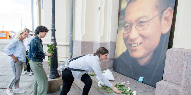 People place flowers and light candles in front a picture of late Nobel Peace Laureate Liu Xiaobo outside the Nobel Peace Center in Oslo, Norway July 13, 2017. NTB Scanpix/Audun Braastad via REUTERS ATTENTION EDITORS - THIS IMAGE WAS PROVIDED BY A THIRD PARTY. NORWAY OUT. NO COMMERCIAL OR EDITORIAL SALES IN NORWAY. TPX IMAGES OF THE DAY
