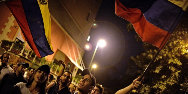 Venezuelan opposition supporters celebrate the results of the legislative election in Caracas, on the early morning December 7, 2015. Venezuela's opposition won --at least--a majority of 99 out of 167 seats in the state legislature, electoral authorities said Monday, the first such shift in power in congress in 16 years. AFP PHOTO/LUIS ROBAYO / AFP / LUIS ROBAYO (Photo credit should read LUIS ROBAYO/AFP/Getty Images)