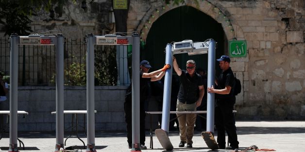 Israeli border policemen install metal detectors outside the Lion's Gate, a main entrance to Al-Aqsa mosque compound, in Jerusalem's Old City, on July 16, 2017, after security forces reopened the ultra-sensitive site, whose closure after a deadly attack earlier in the week sparked anger from Muslims and Jordan, the holy site's custodian. Three Arab Israeli assailants opened fire on Israeli police on July 14 in the Old City, killing two of them before fleeing to the nearby Haram al-Sharif compoun