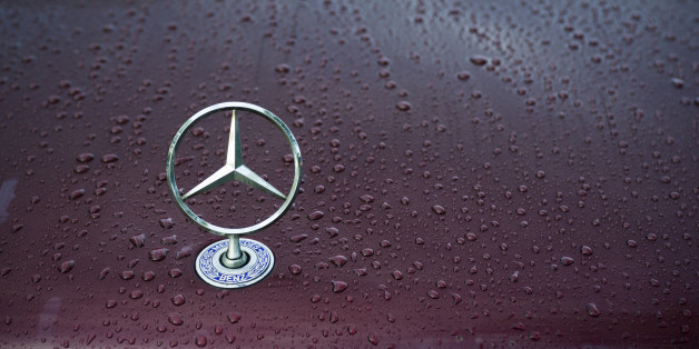 'Padua, Italy - July 6, 2011: Mercedes classical logo on a wet car hood. Mercedes-Benz, a division of Daimler AG, is a German manufacturer of automobiles, buses, coaches, and trucks. The name traces its origins to Daimler 1901 Mercedes and to Karl Benz 1886 Benz Patent Motorwagen, widely regarded as the first automobile. Mercedes today is synonymous with luxury, sportiness and technical reliability. Shot in a public parking.'