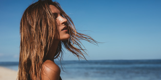Close up portrait of beautiful young woman on the beach. Young caucasian female model on the sea shore.