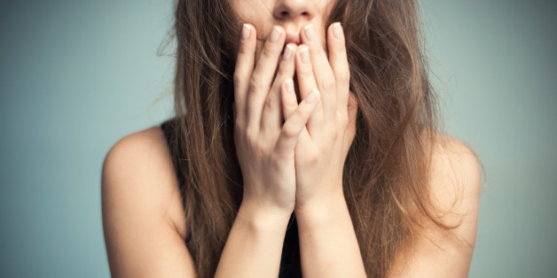 The woman touches finger-tips to the mouth