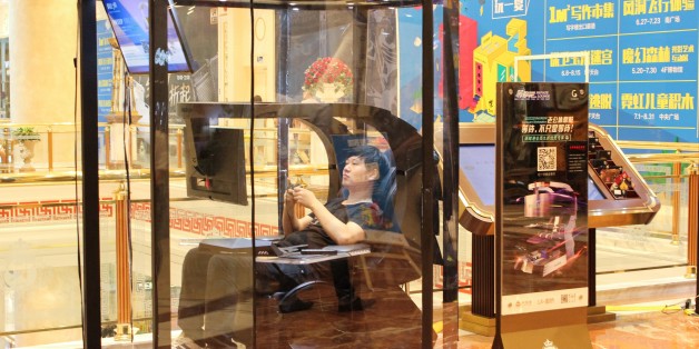This photo taken on July 14, 2017 shows a man playing video games in a booth at a shopping mall in Shanghai.
China has the solution for weary men in shopping malls everywhere: so-called husband rest booths. Its makers say the futuristic mini man caves are a first in China and they have installed four in a high-end shopping centre in Shanghai at a cost of 6,000 USD to make each one. / AFP PHOTO / STR (Photo credit should read STR/AFP/Getty Images)