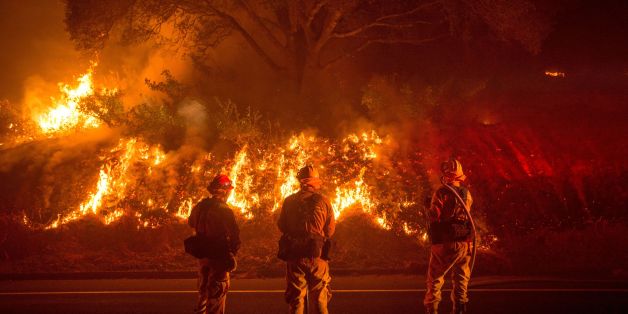 Firefighters monitor flames on the side of a road as the Detwiler fire rages on near the town of Mariposa, California on July 18, 2017.
California has suffered widespread fires in recent days, with a lighting strike near Yosemite National Park sparking a blaze that destroyed more than 26 square kilometers (10 square miles) of forest. / AFP PHOTO / JOSH EDELSON (Photo credit should read JOSH EDELSON/AFP/Getty Images)