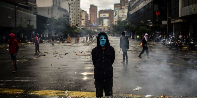 An masked opposition activist takes part in a blockade to protest against Venezuelan President Nicolas Maduro in Caracas, on July 19, 2017.
Venezuela's military chiefs reaffirmed their loyalty to President Nicolas Maduro on Wednesday by saying their forces would protect a controversial vote he has called for next week to elect a body to rewrite the constitution. / AFP PHOTO / RONALDO SCHEMIDT (Photo credit should read RONALDO SCHEMIDT/AFP/Getty Images)
