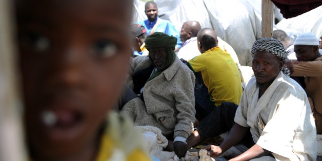 Illegal migrants from Niger sit next to their tents on May 14, 2014 after settling, some of them for more than one year, near the fruit market in the Algerian town of Boufarik, 35 km south of the capital Algiers in the Blida province. The Sahel-Sahara region has been plagued by jihadist violence and severe food shortages. Some Algerian newspapers articles have recently shown signs of racism against African migrants arriving in the country to flee violence and poverty back home. AFP PHOTO/FAROUK BATICHE (Photo credit should read FAROUK BATICHE/AFP/Getty Images)