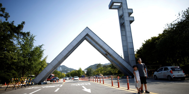 Children pose for photographs in front of Main Gate of the Seoul National University in Seoul, South Korea, August 4, 2016. REUTERS/Kim Hong-Ji AUNI