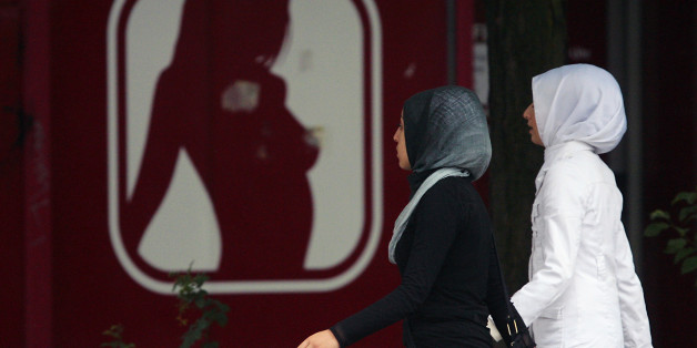 Girls with headscarves walk past a sex shop in Berlin July 12, 2007. Chancellor Angela Merkel's cabinet on Wednesday agreed on measures to improve the integration of Germany's immigrants, including offering more language lessons and making it easier for young people to train. REUTERS/Hannibal Hanschke (GERMANY)