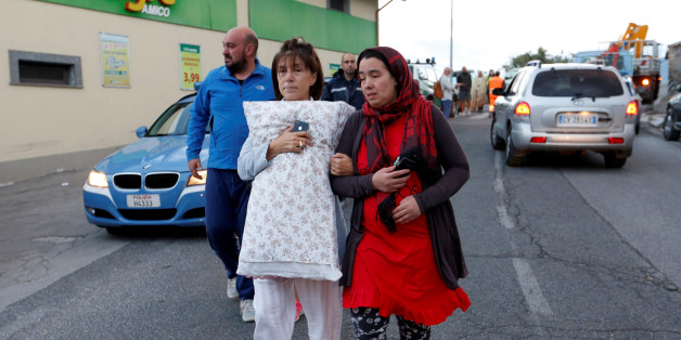 People walk along the road following a quake in Amatrice, central Italy, August 24, 2016. REUTERS/Remo Casilli