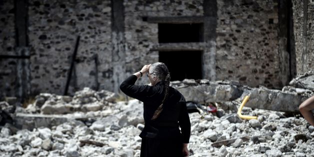 A woman looks at quake-damaged buildings on the Greek Island of Kos on July 22, 2017 , a day after a 6.5 magnitude earthquake struck the region.
The Greek holiday island of Kos was struggling to recover from a 6.7-magnitude earthquake that killed two people and injured hundreds more, battling flight delays and a harbour knocked out for a second day. / AFP PHOTO / LOUISA GOULIAMAKI (Photo credit should read LOUISA GOULIAMAKI/AFP/Getty Images)