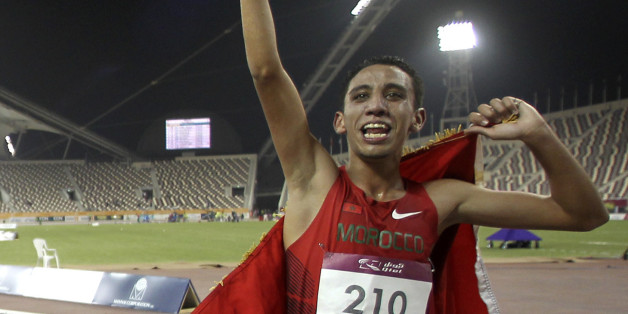 Gold medallist Qatar's Abubaker Ali Kamal (L) and silver medallist Morocco's Soufian Bouqantar celebrate after the men's 5000m final at the 2011 Arab Games in Doha December 20, 2011. REUTERS/Mohammed Dabbous (QATAR - Tags: SPORT ATHLETICS)