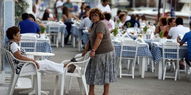 Women talk in the village of Meyisti on the Island of Kastellorizo which is the most easterly of the islands in Greece, July 4, 2015. It was on this island, that former Prime Minister George Papandreou announced in 2010 that Greece required a rescue package. If a 'No' in Sunday's referendum eventually takes Greece out of Europe's single currency, any "new drachma" or temporary payment unit could be worth as little as a fifth of the euro now in circulation. REUTERS/Cathal McNaughton