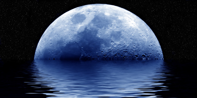 Blue moon rising out of the sea.