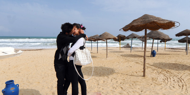 A young Tunisian couple kiss on the empty beach of Hammamet as thousands of Tunisian tour operators and residents of tourist town of Hammamet on April 23, 2011 march under the name 'citizen walk in support of tourism ' . AFP PHOTO FETHI BELAID (Photo credit should read FETHI BELAID/AFP/Getty Images)