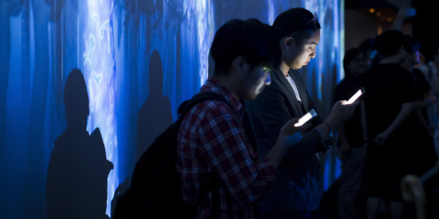TOKYO, JAPAN - JULY 27: Visitors use smartphones as they stand in front of a digital installation produced by teamLab, an art collective, during the teamLab Jungle Light Art and Music Festival & Learn and Play! Future Park exhibition at the Shibuya Hikarie commercial complex on July 27, 2017 in Tokyo, Japan. The exhibition is opened to the public through September 10 to commemorate Shibuya Hikarie's 5th anniversary since its establishment. (Photo by Tomohiro Ohsumi/Getty Images)