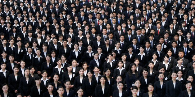 Newly-hired employees of Japan Airlines (JAL) group pose for photos during an initiation ceremony at a hangar of Haneda airport in Tokyo, Japan, April 3, 2017. REUTERS/Toru Hanai