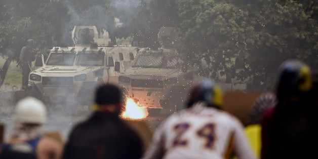 Opposition activists clash with riot police during a protest against President Nicolas Maduro's government and in defiance of a new ban on rallies ahead of Sunday's controversial vote in Caracas on July 28, 2017.
Venezuela careened towards a showdown Friday between anti-government protesters and security forces, as the death toll from months of demonstrations against embattled President Nicolas Maduro mounted -- as did international concern about the spiraling violence.
/ AFP PHOTO / RONALDO SCHEMIDT (Photo credit should read RONALDO SCHEMIDT/AFP/Getty Images)
