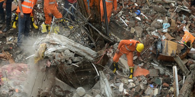 Indian rescue workers and fire officials look for survivors in debris at the site of a building collapse in Mumbai on July 25, 2017.
Rescuers were frantically searching for up to 40 people feared trapped in a four-storey building that collapsed July 25 in India's financial capital of Mumbai, officials said. / AFP PHOTO / PUNIT PARANJPE (Photo credit should read PUNIT PARANJPE/AFP/Getty Images)