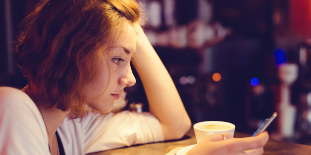Girl in a cafe texting on smartphone - copyspace