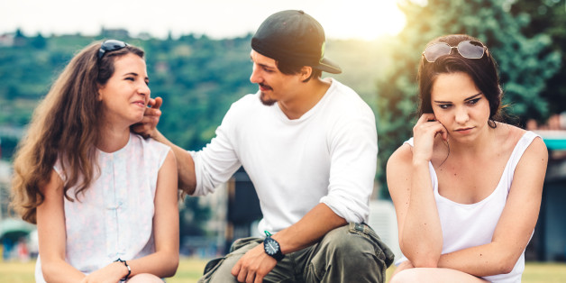 Jealous girl sitting beside loving couple.