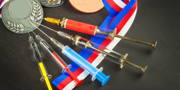 Syringe and medals. Doping in sport. Abuse of anabolic steroids for sports. Anabolic steroids spilled on a wooden table. Fraud in sports. Doping athletes.