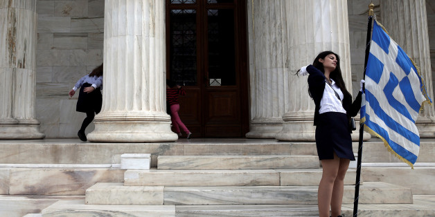 Children (L) play hide and seek as a student holds a Greek national flag at the entrance of the Athens Academy, following a student parade marking the "Ohi" (No) day, the country's rejection on Italy's ultimatum to surrender as the World War II flared up, in Athens, Greece, October 28, 2016. REUTERS/Alkis Konstantinidis