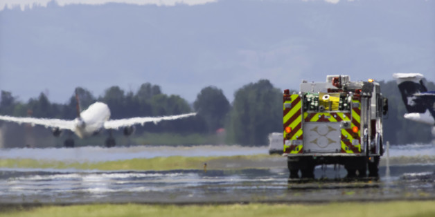 Aircraft taking off with firetruck on runway