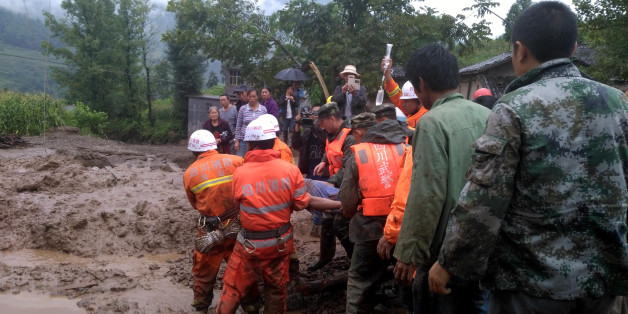 Rescuers carry a survivor at the site of a landslide in Puge in China's southwestern Sichuan province on August 8, 2017. A landslide triggered by heavy rain killed 8 people and left 17 others missing. / AFP PHOTO / STR / China OUT (Photo credit should read STR/AFP/Getty Images)