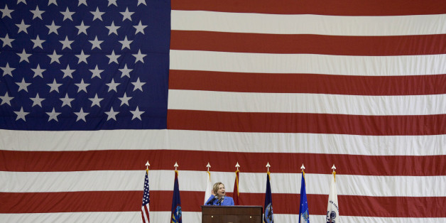 US Secretary of State Hillary Clinton listens for cheers from US troops during an event at Andersen Air Force Base on the island of Guam on October 29, 2010. Clinton arrived for a brief stopover in the US Pacific territory of Guam to meet US troops and local Governor Felix Camacho before heading to Vietnam to take part in the the Association of Southeast Asian Nations (ASEAN) summit. AFP PHOTO / POOL / Evan Vucci (Photo credit should read Evan Vucci/AFP/Getty Images)