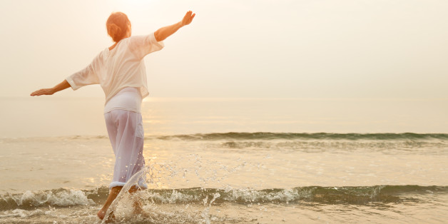 Carefree woman dancing in the sun on the beach